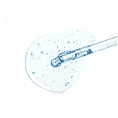 Pipette dispensing clear liquid onto a white surface.