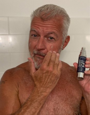 Man applying Particle Face Cream on his face.