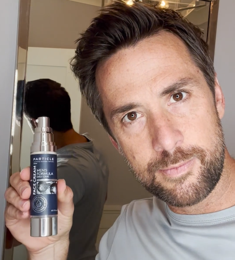 Man shows Particle skincare product.