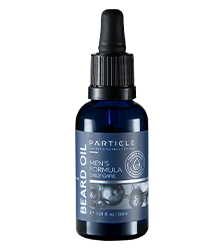 A dark blue bottle labeled Particle Beard Oil, Men's Formula Daily Care with a black pump top.