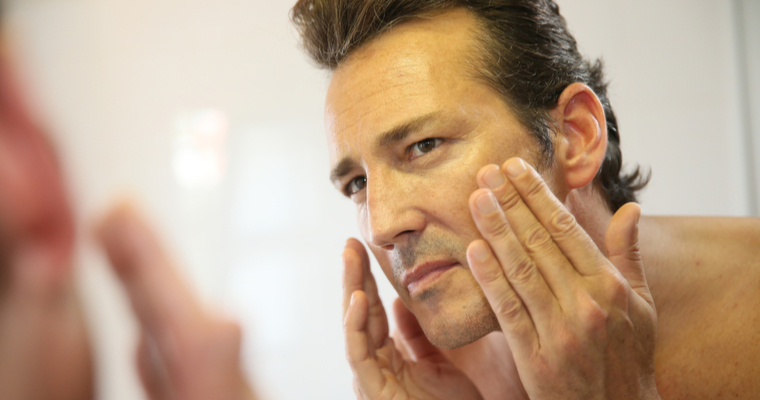 Man-looking-at-his-skin-in-the-mirror-skincare