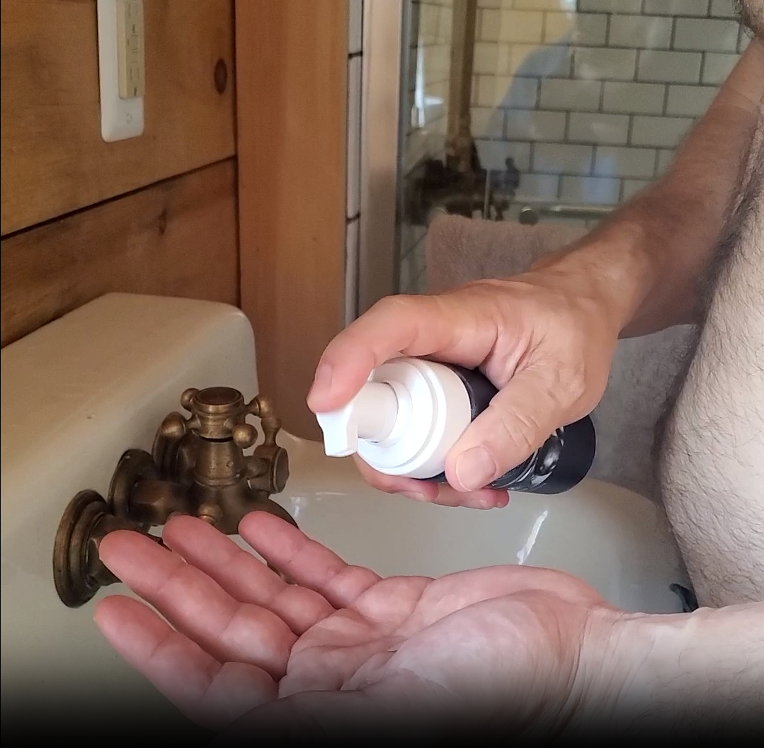 Hands dispensing foam from a Particle pump bottle. 